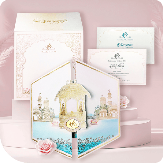 Discover the perfect blend of luxury and elegance with this Hexagon Folder Wedding Card. Featuring a unique door-style design, this sky-blue invitation with a soft pink border is adorned with intricate gold foil artwork and a stunning golden acrylic mirror emblem. The card opens vertically to reveal two premium inserts, designed to elegantly present your wedding details. Ideal for royal, destination, and luxury weddings, this card is a statement piece of sophistication and grandeur.