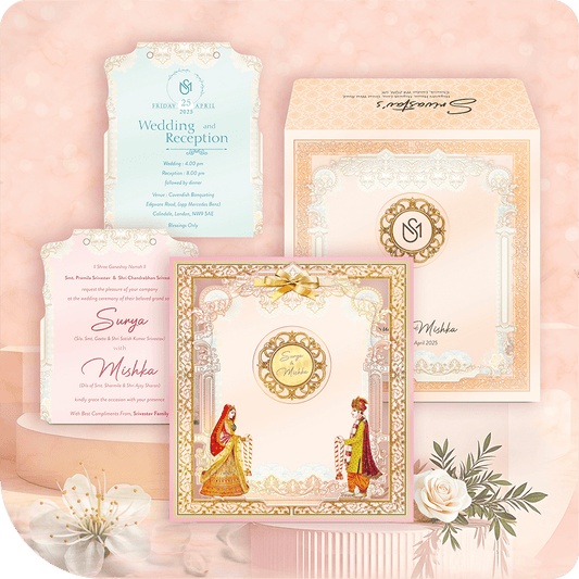 Luxury MDF wedding invitation suite with traditional Hindu bride and groom figures, pastel pink/peach border, and intricate gold foil pattern.